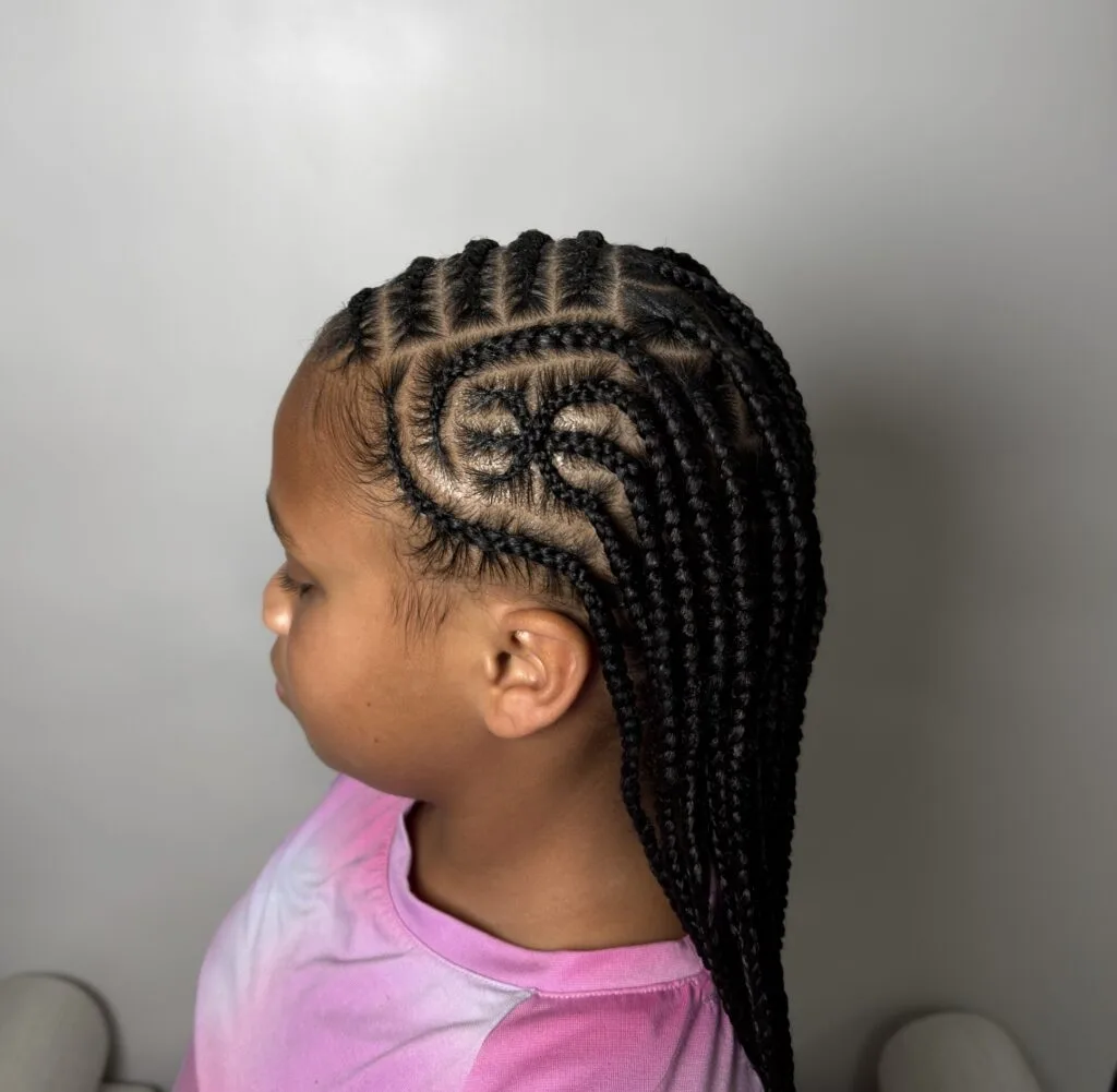 Child with braids in side profile in front of the Nerielle Braiding Studio logo wall